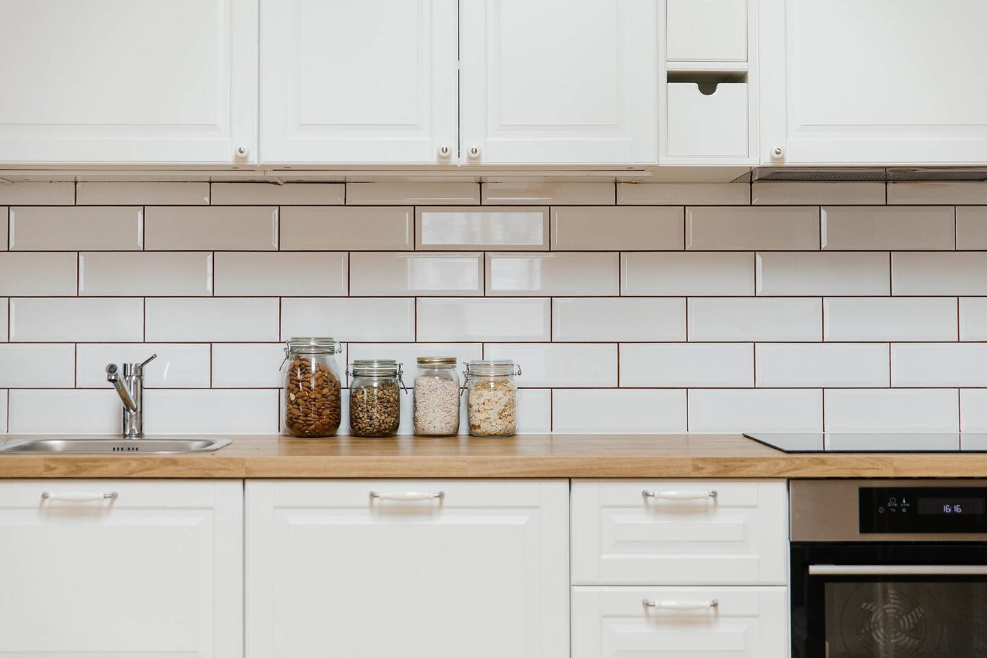 Jelen – bílá kuchyně s dřevěnou pracovní deskou