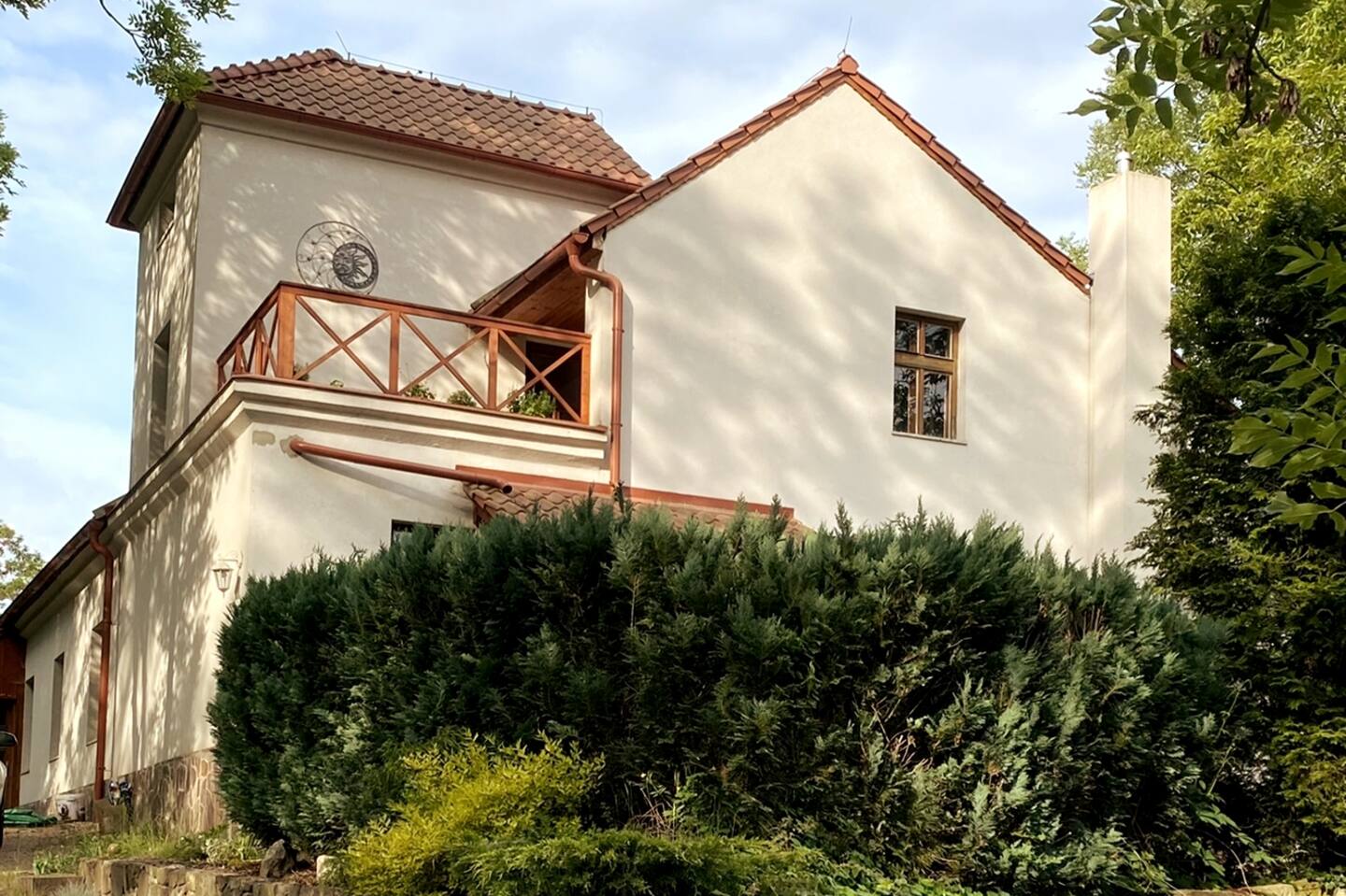 Chalupa pod jasany – fasáda s balkónem v odpoledním světle